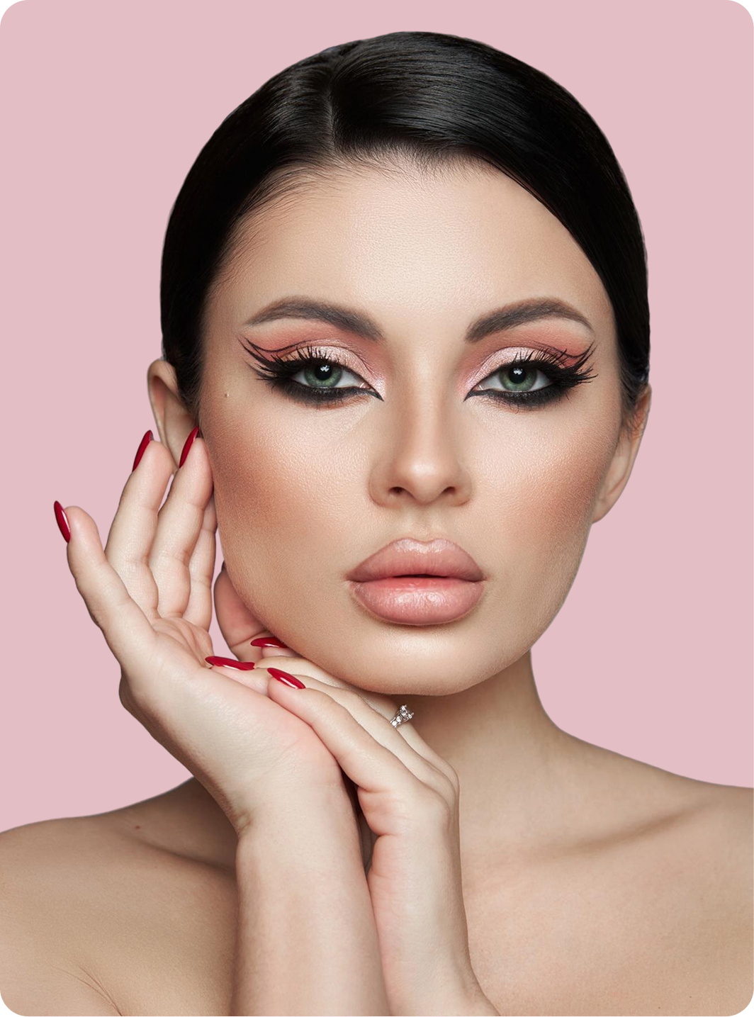 A close-up portrait of a woman with dramatic eye makeup, long red nails, and a ring, posed against a solid pink background.